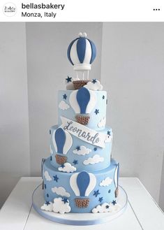 a blue and white cake with hot air balloons on it