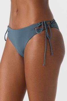 Head to the beach in this sweet and stylish bikini bottom. It has a strappy side tie design and skimpy rear coverage fit. O'Neill Women's bikini bottom Saltwater Solids Skimpy rear coverage Lace up side detail 85% Recycled Polyamide 15% Elastane | O'Neill Women's Saltwater Solids Jensen Skimpy Bottoms in Slate, Size XS, Elastane/Polyamide Strappy Summer Pool Bottoms, Strappy Beachwear Bottoms For Swimming, Strappy Beachwear Bottoms For Beach Season, Strappy Beachwear Bottoms For Pool, Beachy Swimwear With Side Ties For Pool, Summer Strappy Beachwear Bottoms, Strappy Summer Beachwear Bottoms, Stretch Bottoms With Adjustable Straps And Tie-side, Adjustable Straps Tie-side Swim Bottoms