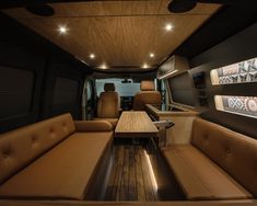 the inside of a bus with couches, tables and lights on it's ceiling