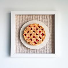 a white plate topped with a pie on top of a wooden table next to a wall