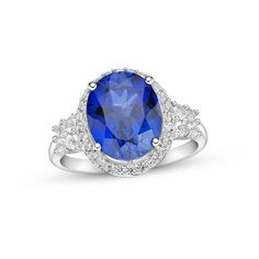 A sumptuous oval-cut blue lab-created sapphire draws the eye to this entrancing cocktail ring. Sparkling white lab-created sapphires shimmer around the center and adorn the band, which is crafted in classic sterling silver. Oval Brilliant Cut Party Ring, Oval Party Ring With Center Stone, Oval Diamond Gemstone Ring For Party, Oval Diamond Ring For Party, Oval Cubic Zirconia Diamond Ring With Gemstone Accents, Oval Diamond Ring With Cubic Zirconia And Gemstone Accents, Oval Cubic Zirconia Ring With Gemstone Accents, Blue Diamond Ring With Gemstone Accents, Oval Shape, Blue Oval Diamond Ring With Gemstone Accents