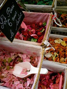 several bins filled with different types of dried flowers