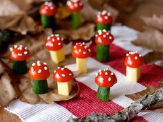 small mushrooms are sitting on top of green and yellow sticks in the middle of a table cloth