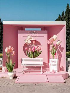 there is a bench and flowers in front of a pink building