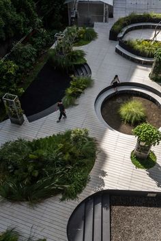 an aerial view of people walking around in a courtyard with trees and plants on the ground