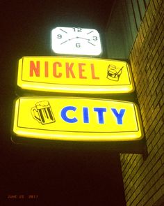 two neon signs on the side of a building that says nickel city and beer