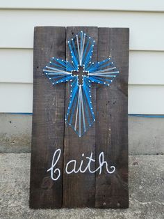 a wooden sign with the word faith painted on it and a cross in the middle