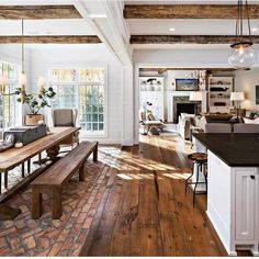 a large open concept living room with wood flooring and exposed beams in the ceiling