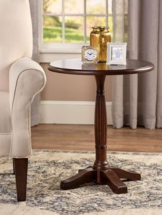 a small table with a clock on it in front of a chair and window sill