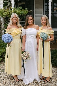 three women in yellow dresses standing next to each other with bouquets on their hands