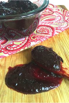 two pieces of food sitting on top of a wooden cutting board next to a bowl