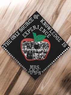 a black and white graduation cap with an apple on it that reads the front source of knowledge