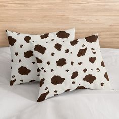 two brown and white pillows sitting on top of a bed