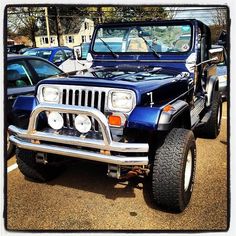 a jeep parked in a parking lot next to other cars