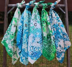 several different colored bandanas hanging from a fence