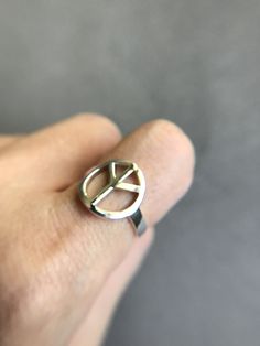 Silver Peace Sign Ring - Sterling Silver [R1029] Quantity : One Ring Color : Silver Material : Sterling Silver Ring Size : 5 / 6 / 7 / 8 / 9 /10 Ring Detail : about 2.5 wide 1.5mm thick Peace Size : 14mm * Metal components are Sterling Silver. * Suitable for delicate and sensitive skin. * Comes in a jewelry box. If you need extra boxes for gifting....just let us know! Adjustable Symbolic Nickel-free Midi Rings, Adjustable Nickel-free Symbolic Midi Rings, Casual Metal Rings For Gifts, Peace Sign Ring, Ring Color, Silver Prices, One Ring, Peace Sign, Ring Sterling Silver