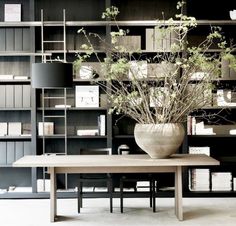 an image of a table and shelves with flowers in the vase on it, as well as other items