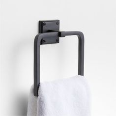 a towel hanging on the wall next to a toilet paper holder with two black handles