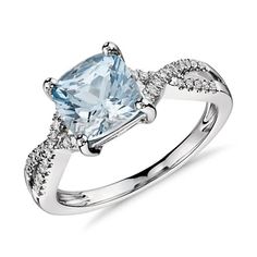 a white gold ring with an aqua blue topazte and diamonds