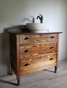 a bathroom sink sitting on top of a wooden dresser