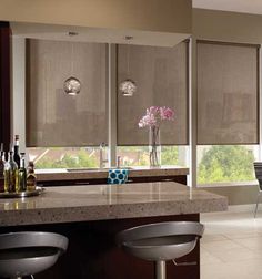 a kitchen with two bar stools next to a counter and window covered in blinds