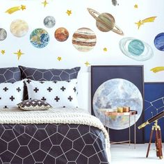 a bed room with a neatly made bed and planets on the wall