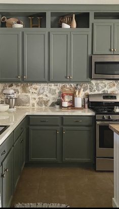 a kitchen with green cabinets and white counter tops