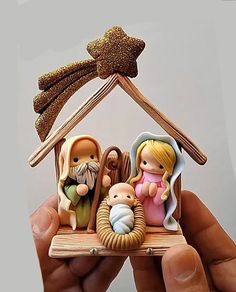 a hand holding a small nativity figurine