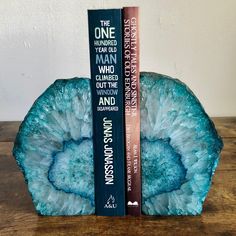 two books sit on top of each other in front of a bookend that is shaped like a rock