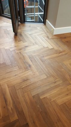 an empty room with wooden floors and glass doors