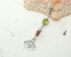 Lotus Flower Belly Ring Show off your beautiful belly! Belly ring features Picasso beads with a white base, green and ruby red swirls, ruby gemstone bead in the center and your choice of charm. Belly ring measures 2 3/8 inches long total length. Barbell is 14g surgical steel with a prong set green crystal gem. For Belly Button Rings: https://www.etsy.com/shop/AllAboutClass?section_id=18474235&ref=shopsection_leftnav_1 For Industrial Barbells: https://www.etsy.com/shop/AllAboutClass?ref=l2-sh Adjustable Green Belly Rings As Gift, Hibiscus Belly Button Ring, Adjustable Dangle Belly Rings, Bridal Body Jewelry, Lizard Belly Button Ring, Unique Belly Rings, Adjustable Nickel-free Dangle Belly Rings, Dangle Belly Button Piercing Tummytoys® At The Belly Ring Shop, Belly Button Jewelry