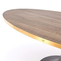 an oval wooden table with metal legs and a wood grain top, against a white background