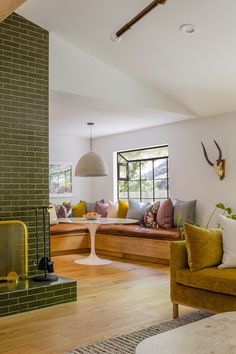 a living room filled with furniture and a fire place in front of a brick wall