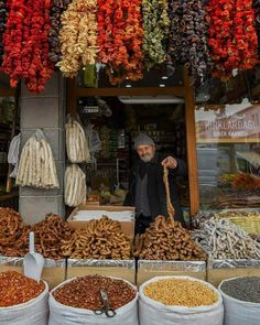 a man standing in front of a store filled with lots of different types of food