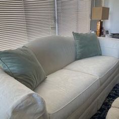 a living room with white couches and pillows