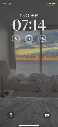 an image of a bed with the time displayed on it's screen and window overlooking the ocean