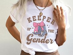 a woman wearing a t - shirt that says keeper of the genderer