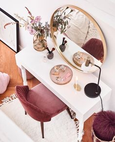 a white table topped with a mirror next to a purple chair