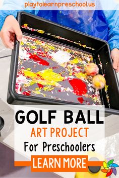 a person holding a tray with paint on it and the words golf ball art project for preschoolers learn more