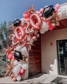 the balloon arch is decorated with stars, balloons and confetti to celebrate someone's 90th birthday