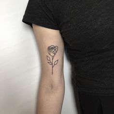 a black and white rose tattoo on the right arm by a woman's left arm