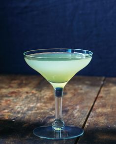 a green drink sitting on top of a wooden table