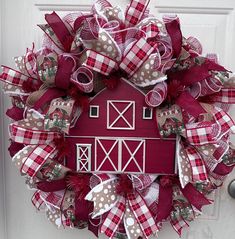 a red and white wreath with a barn on it