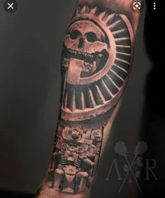 a man's arm with a black and grey tattoo on it, depicting an image of a skull