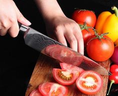 a person slicing tomatoes on a cutting board with a knife