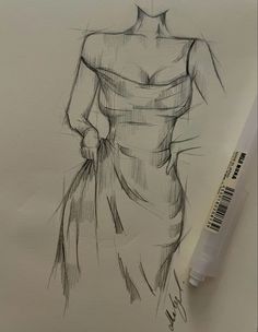 a drawing of a woman's dress on paper next to a marker and pen