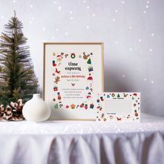 there is a small christmas tree next to a card and some decorations on the table