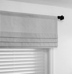 a black and white photo of a window with blinds