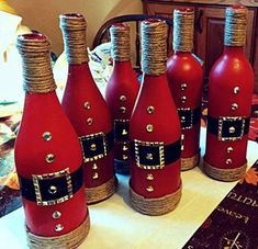 six red wine bottles decorated with jewels and pearls