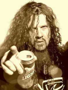 a man with long hair is holding a drink